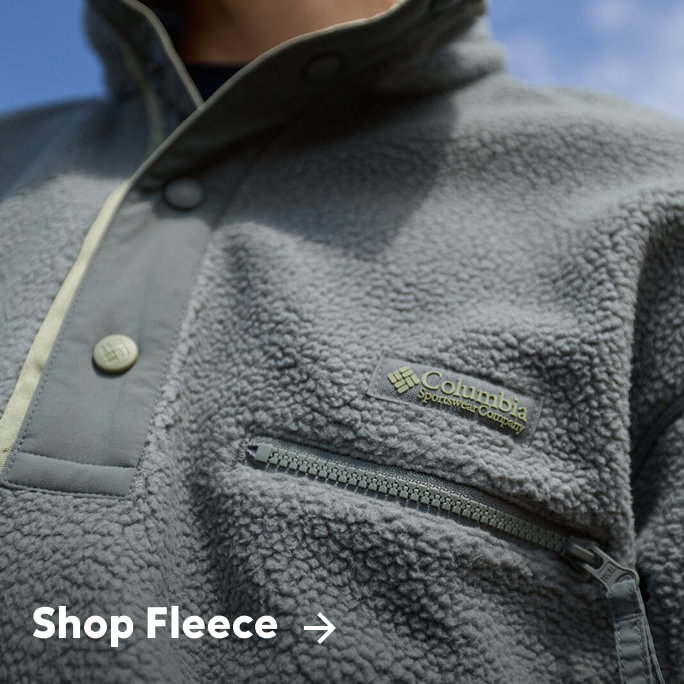 Close-up of a person's green fleece pullover with text: Shop Fleece