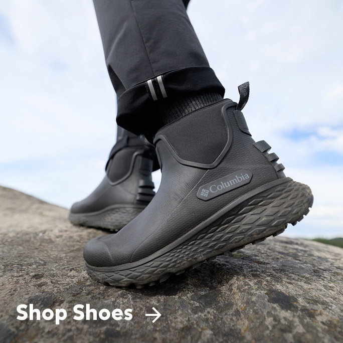 Close-up of someone's black ankle boots with text: Shop Shoes
