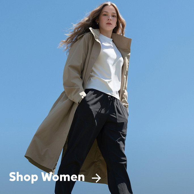 A woman in a tan trench coat against a blue sky with text: Shop Women