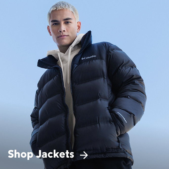 A man wearing a white hoodie and black puffer with text: Shop Jackets