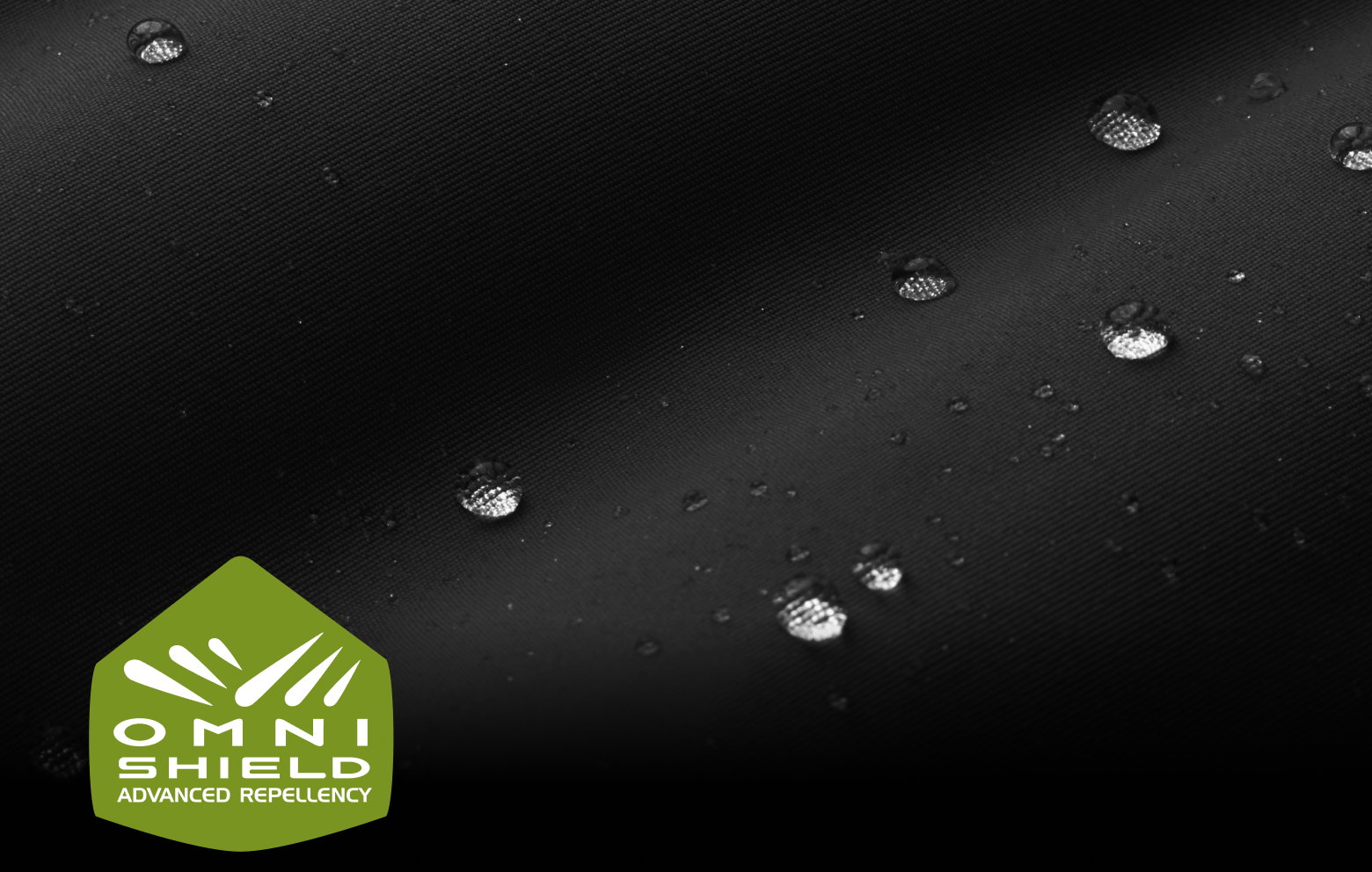 Close-up of moisture beading on black fabric with the Omni-Shield logo.