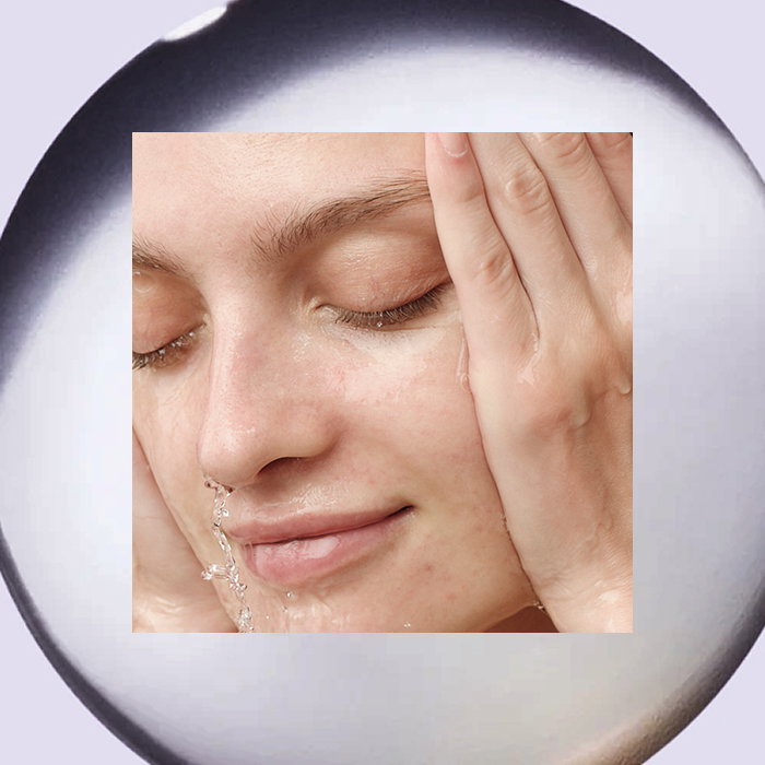 An image of a model cleansing her face with The Camellia Cleansing Oil by Tatcha