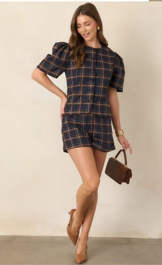 Woman wearing a Navy & Camel Plaid Puff Sleeve Top with matching shorts.