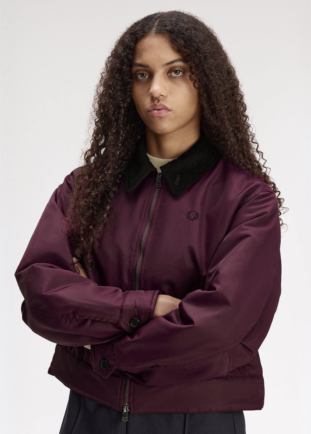 A female model wearing a Fred Perry Padded Caban Jacket in Plum