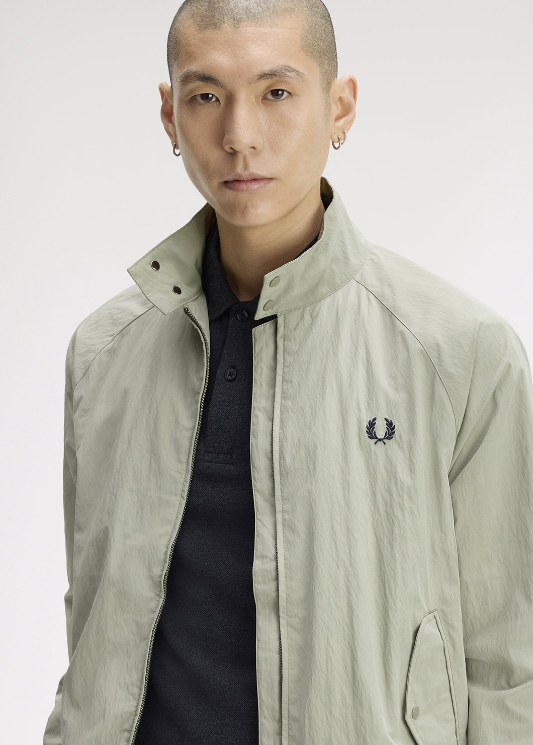 A male model wearing a Fred Perry Crinkle Harrington Jacket in Seagrass