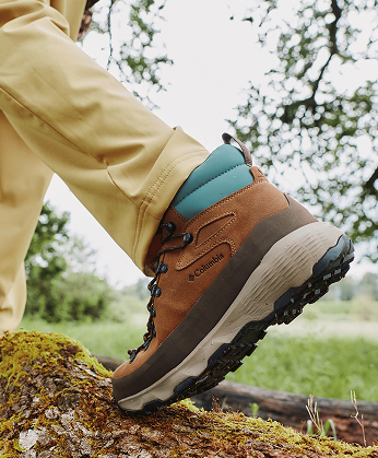 Close-up of a hiker's brown hiking boot on a log.