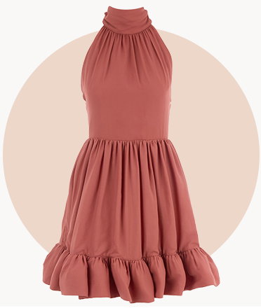 Dusty rose halterneck mini dress with gathered detailing and a ruffled hem, displayed against a beige circular background.
