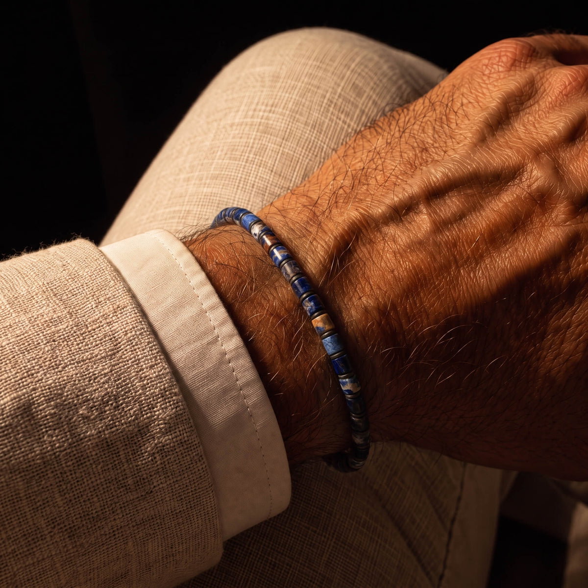 Sodalite Bracelet IX (4mm) worn on the wrist with a beige jacket.