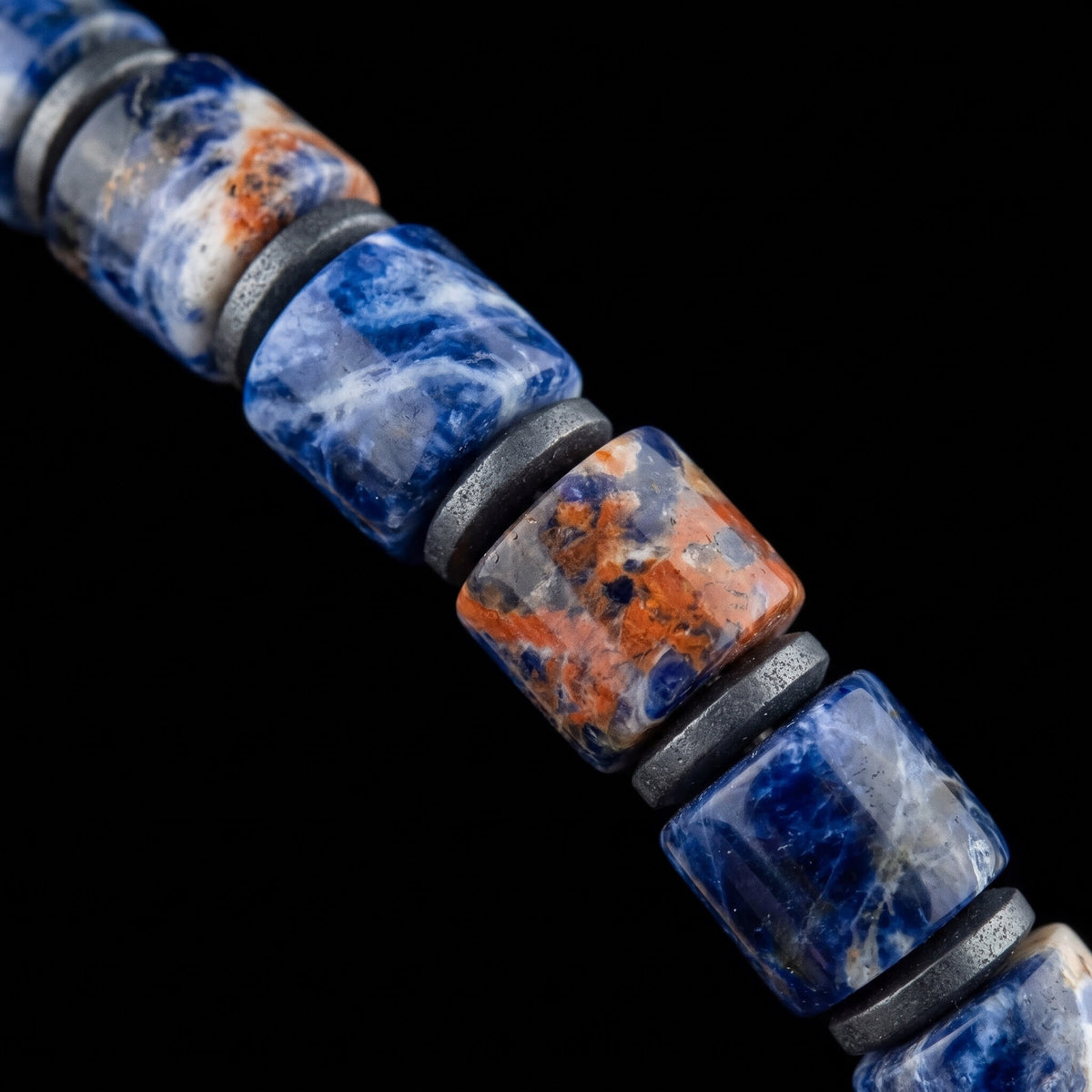 Macro detail of Sodalite Bracelet IX (4mm), showing blue and white stone patterns, orange tones and hematite spacers.