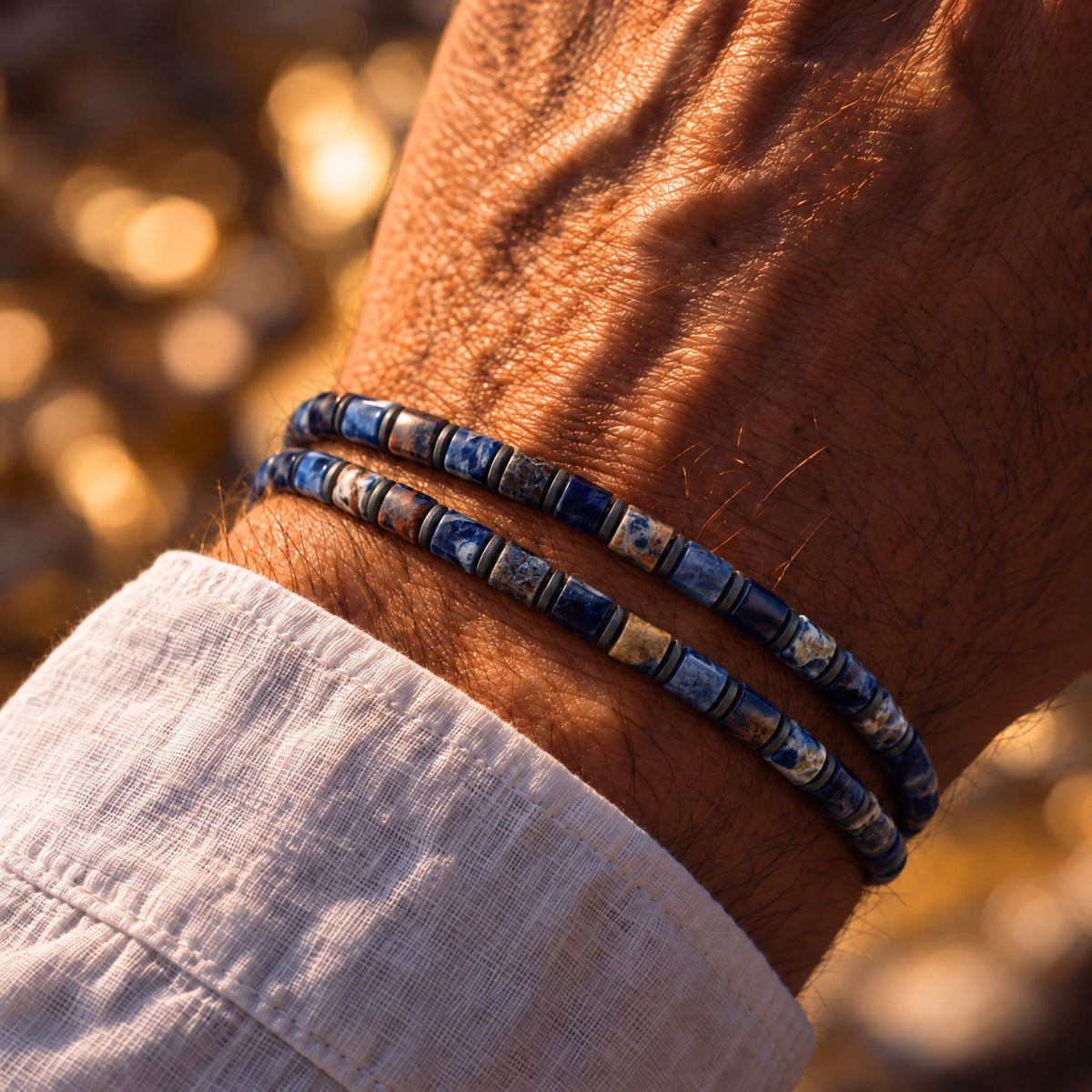 Two Sodalite Bracelet IX bracelets worn together on the wrist with a white linen cuff.