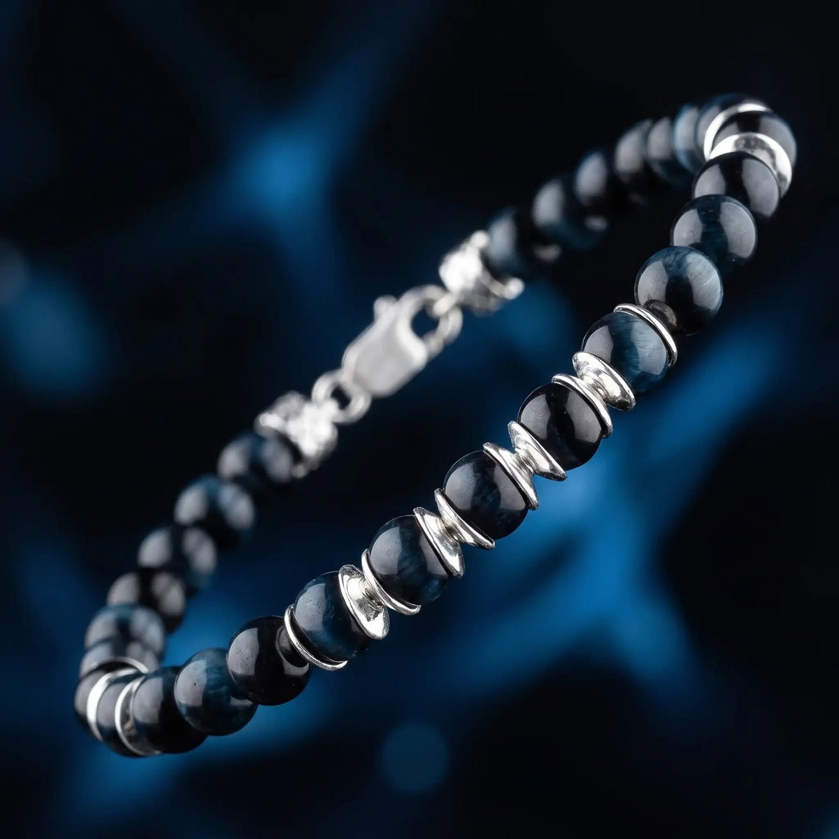 Blue Tiger Eye Bracelet IV (6.5mm), showing the full bracelet and paired sterling silver spacers against a dark blue background.