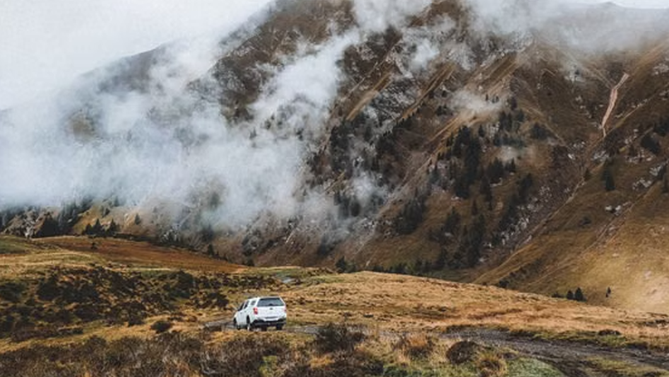 White SUV driving on a foggy mountain road