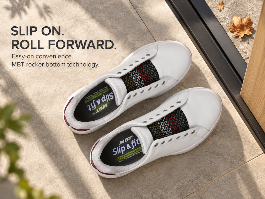 Pair of white MBT Slip & Fit shoes on a stone floor with the message “Slip On. Roll Forward. Easy-on convenience. MBT rocker-bottom technology.