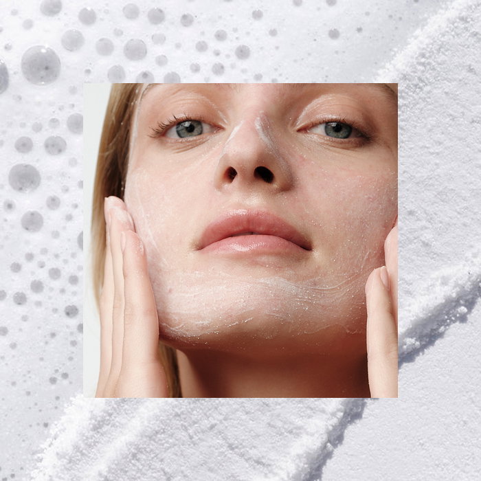 An image of a model cleansing her face with The Rice Polish by Tatcha