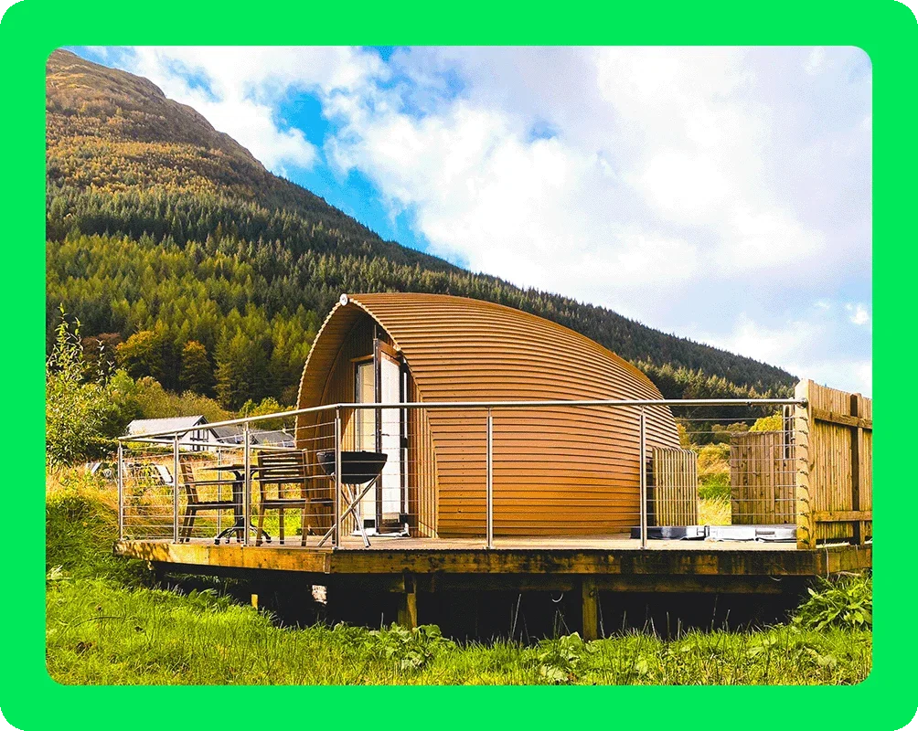 Image Description: A dome-shaped building in a grassy field near a mountain.