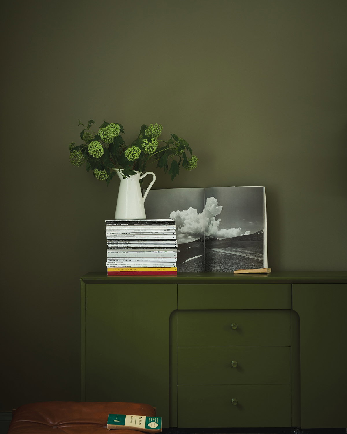 Living room painted in Treron green with a Bancha-painted cabinet, creating a rich and cosy autumnal space with layered natural tones. 