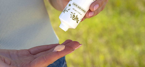 Woman applying hand cream outside