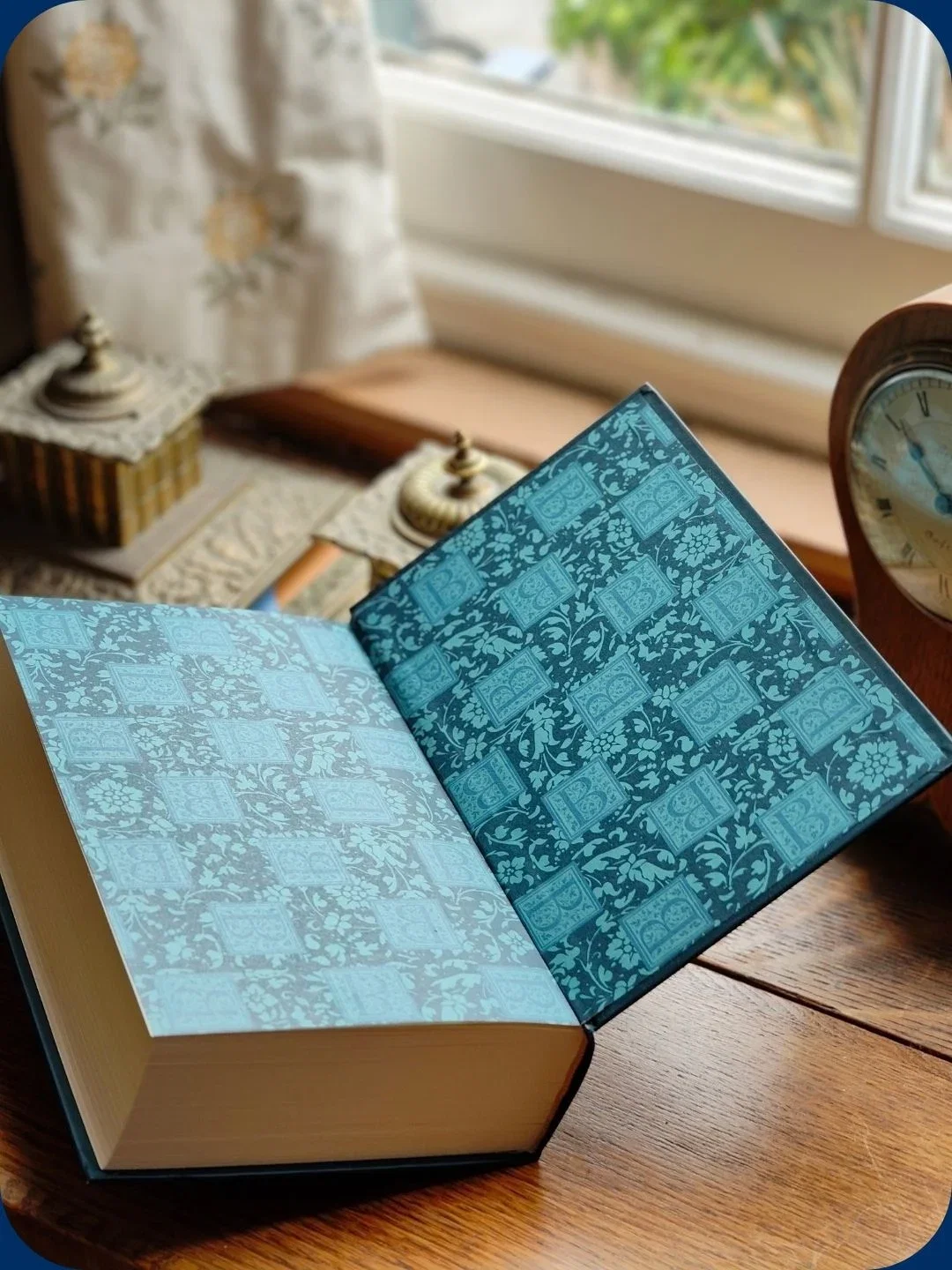 Open book with blue patterned pages near clock.
