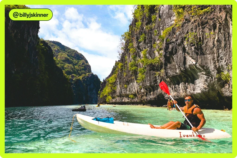 Image description: A man kayaking in a lush, rocky area, photo taken by @billyjskinner