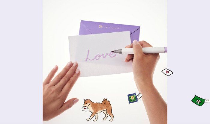 An image of hands writing a gift note to loved ones