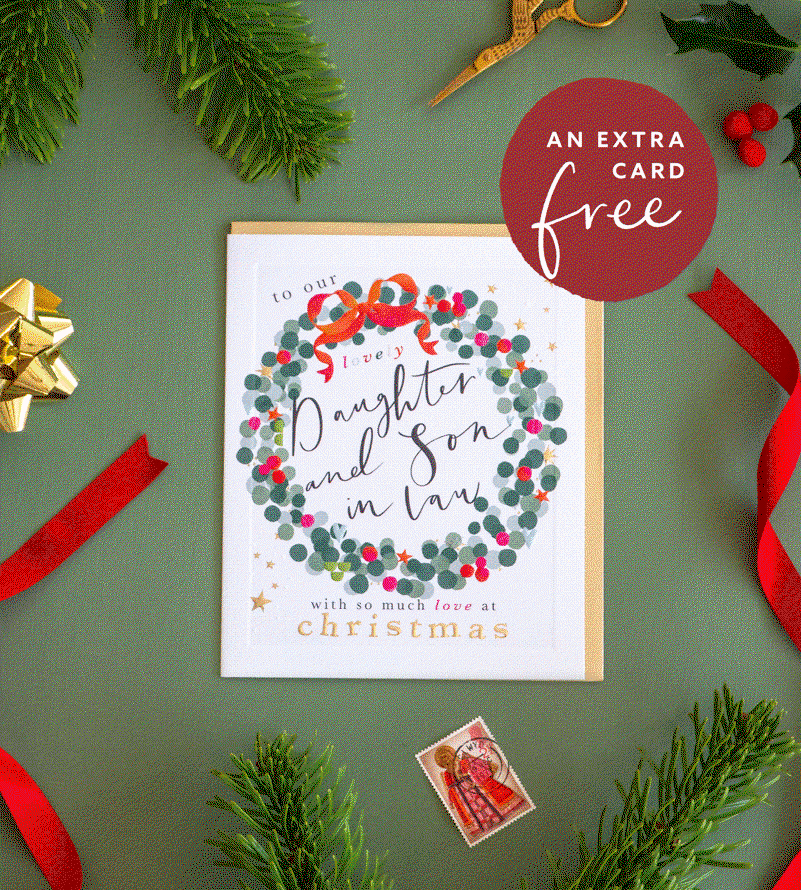 Festive Christmas card displayed with ribbon, greenery and gift wrap. Promotional badge reads: “An extra card free.”