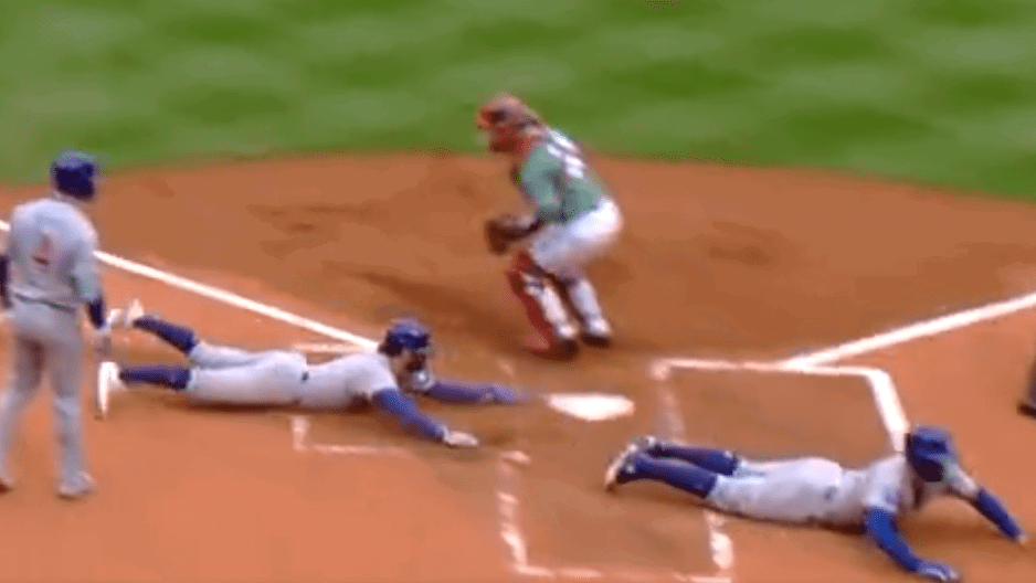 One Cubs runner slides into home plate just after a runner before him