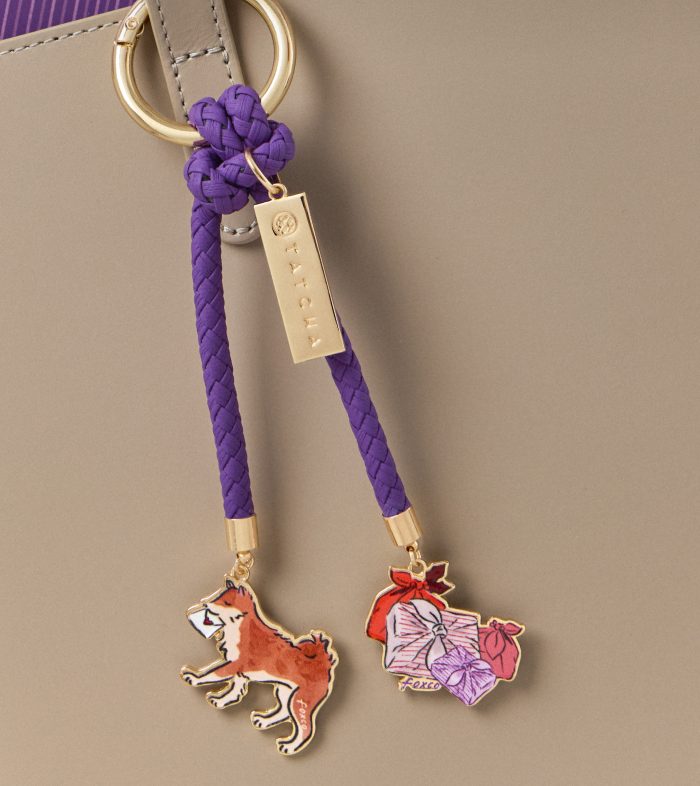 An image of a bag charm complimentary with any new holiday gift set