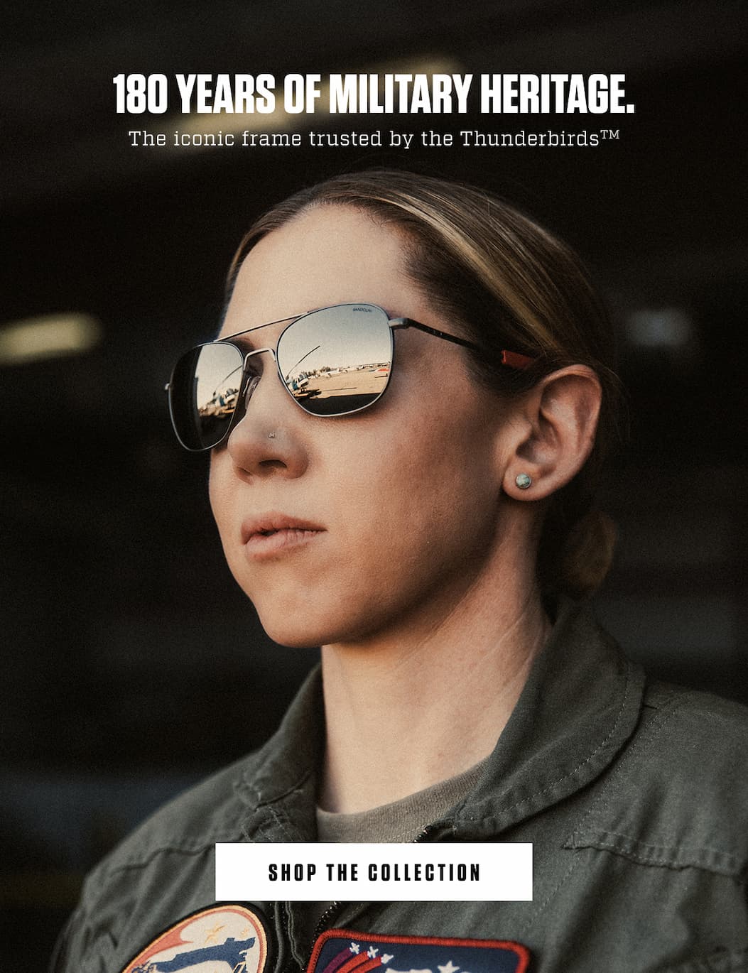 Woman in a flight suit wearing Randolph aviator sunglasses with reflective Gentex Silver lenses.