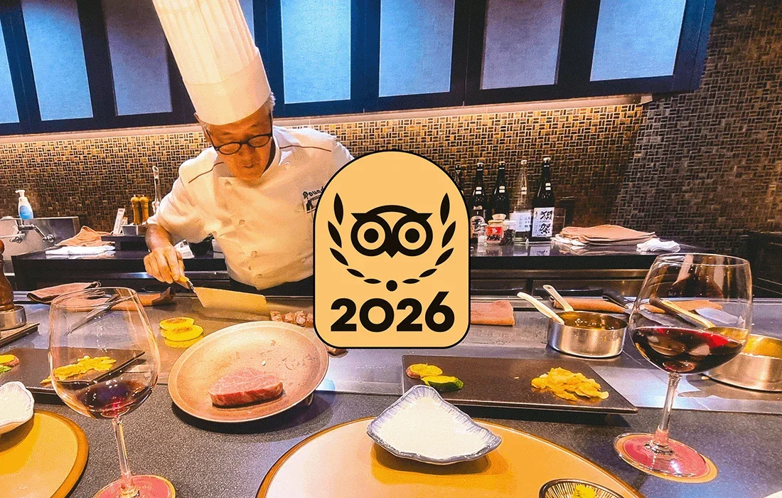 Image Description: Hibachi experience with a chef in a white chef’s coat and hat at the flat top grill. Travelers’ Choice Best of the Best gold badge overlaid in the center of the image.