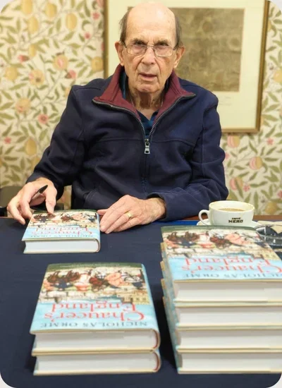 Professor Orme signing books at a table.