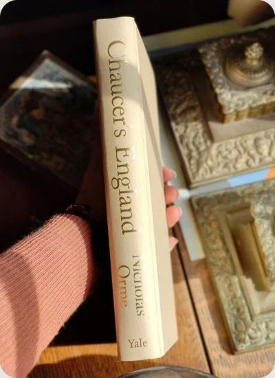 Hand holding book 'Chaucer's England' by Orme.