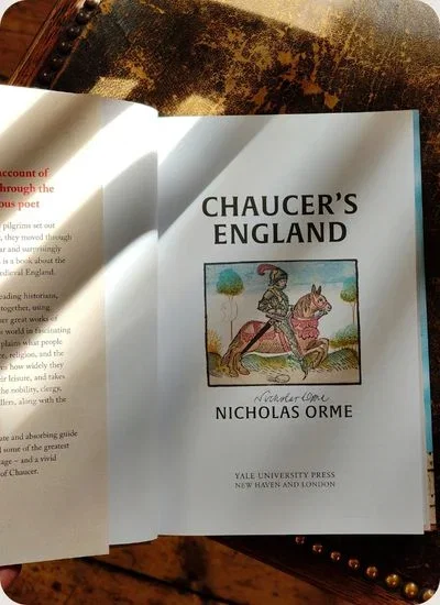 "Chaucer's England" book open on a table.